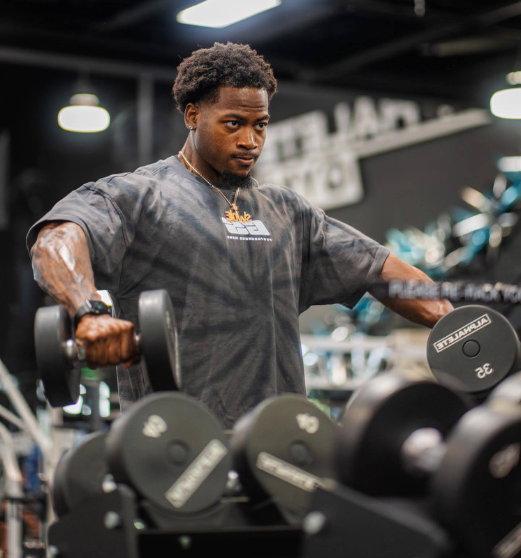 The coach is holding the dumbbell with each hand.
